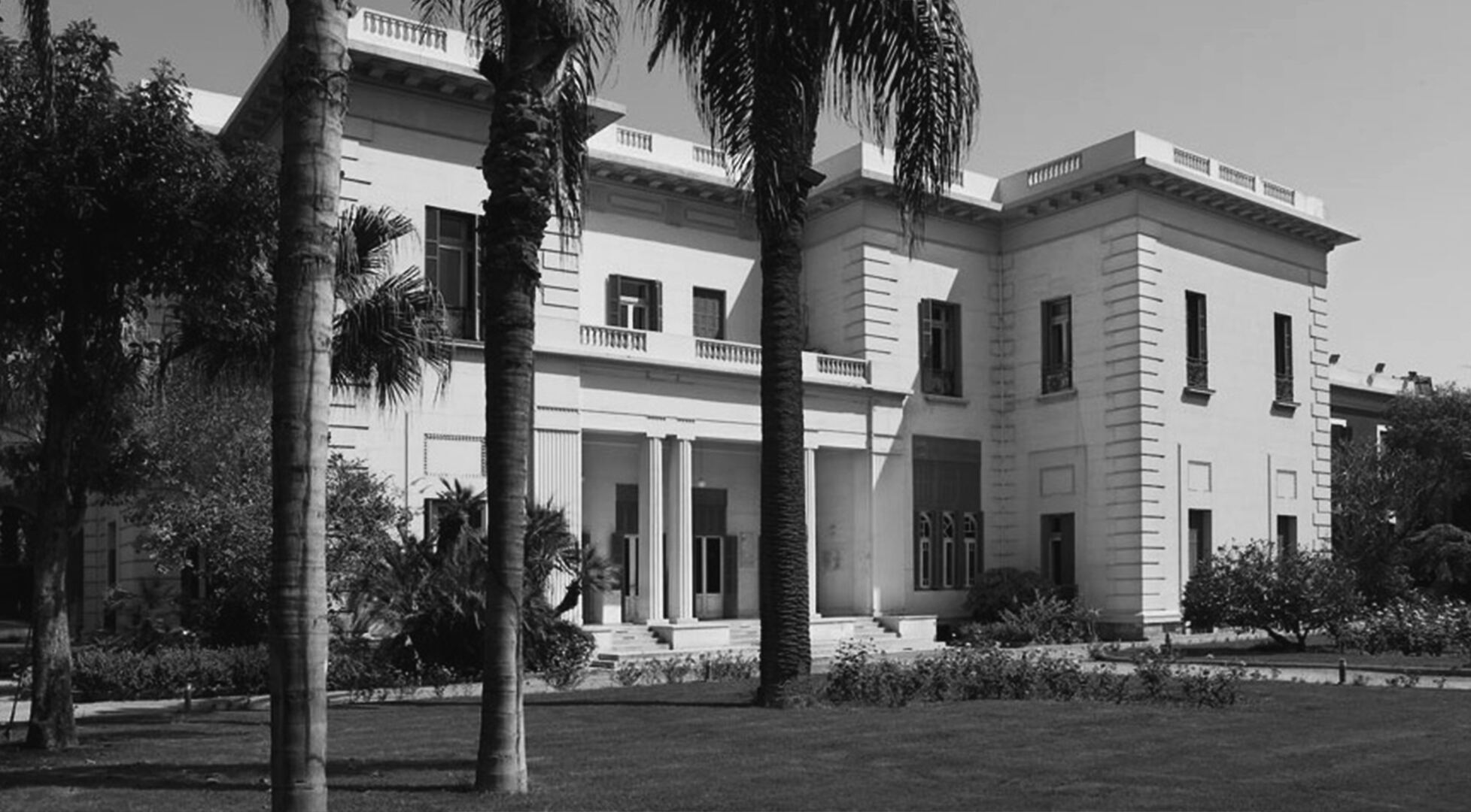 Classical embassy villa framed by palm trees, seen through the CCS C mark